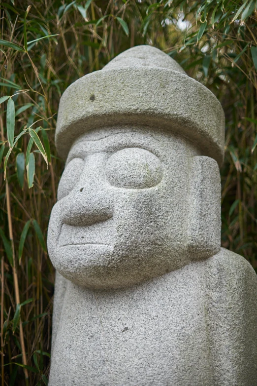 a large stone statue standing next to the jungle