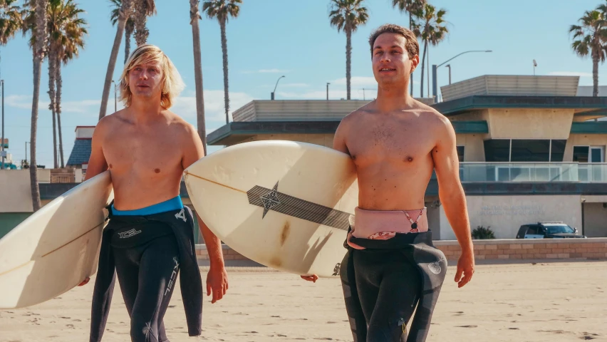 two people standing next to each other on the beach