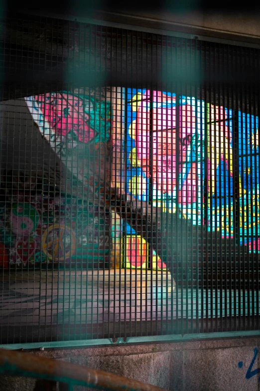 colorful bars are on the metal fence by a skateboard