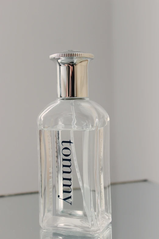 a glass bottle with silver cap on a table