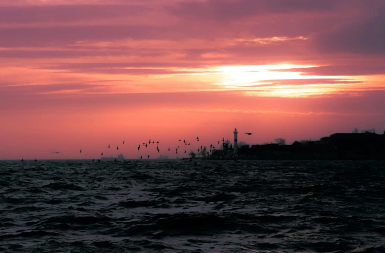 a red sky is shining over the ocean