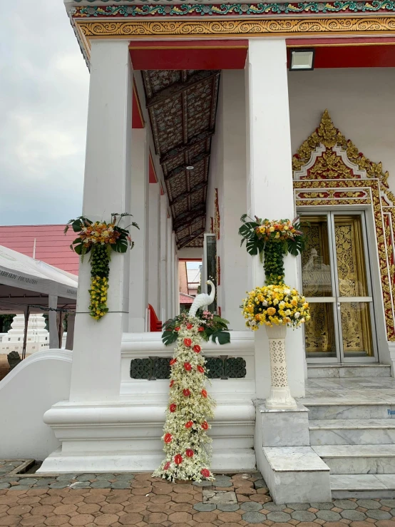 decorative flowers stand on the step of a large building