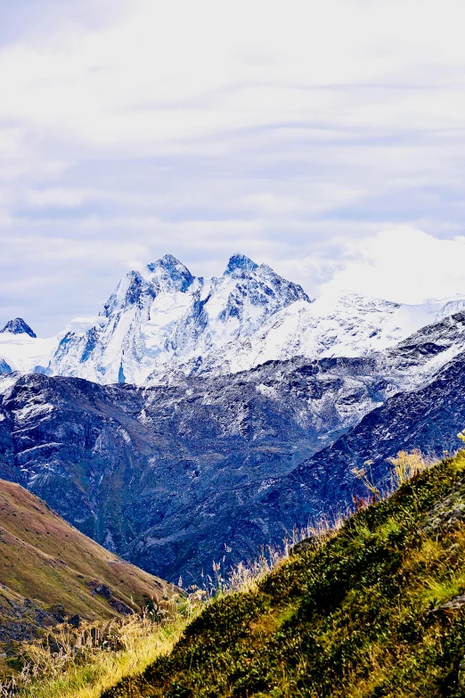 mountain range covered in snow, with some hills in the background