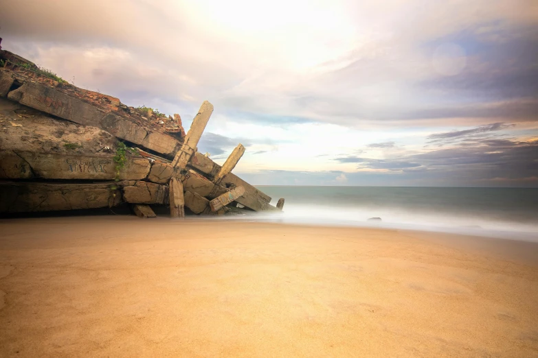 a large rocky outcropping sitting on the shore of a beach