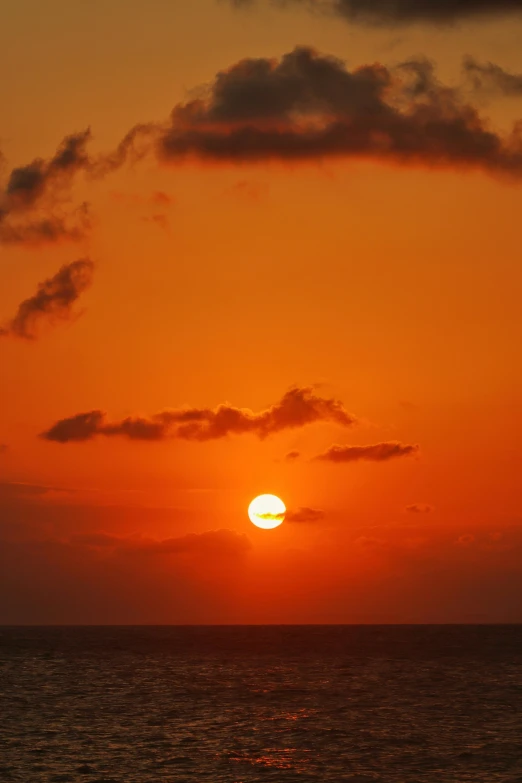 the setting sun with a boat in front