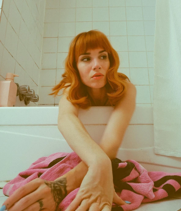 a young woman lying on the ground in a bathroom
