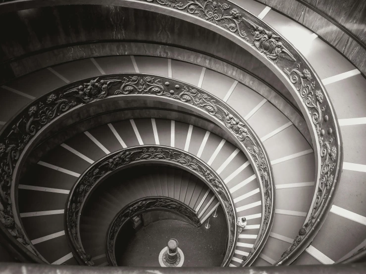 black and white po of spiral staircase leading to another space