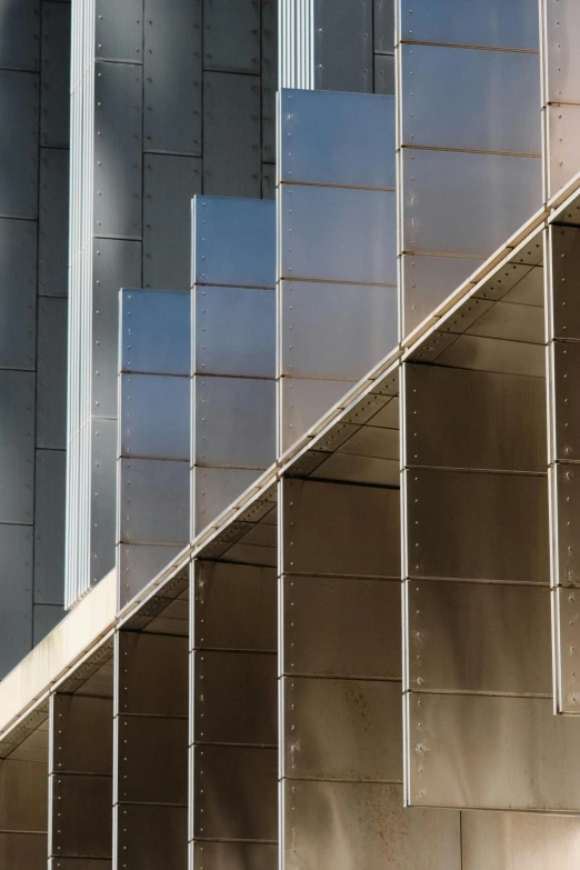 a tall clock on the side of a building next to a staircase