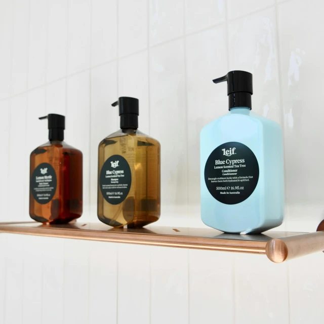 three bottles sitting on top of a shelf next to soap