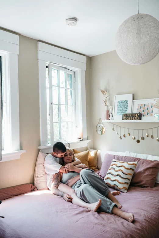 man and young woman sitting on a bed in a bedroom