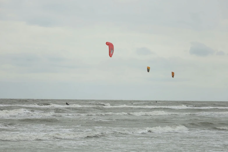 two people on the ocean flying kites