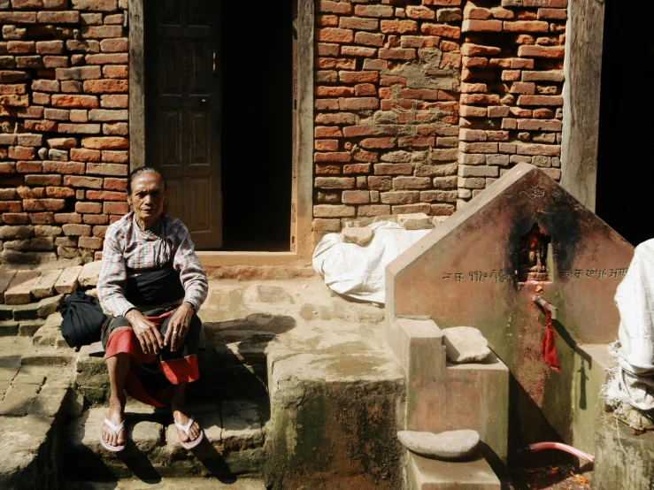 a man sitting on top of steps by a building