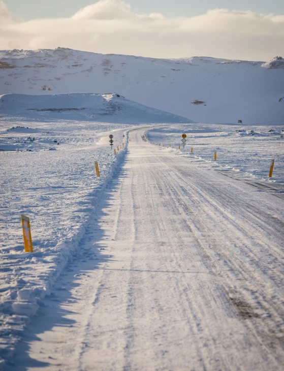 the long and snow - covered road leading into a mountain