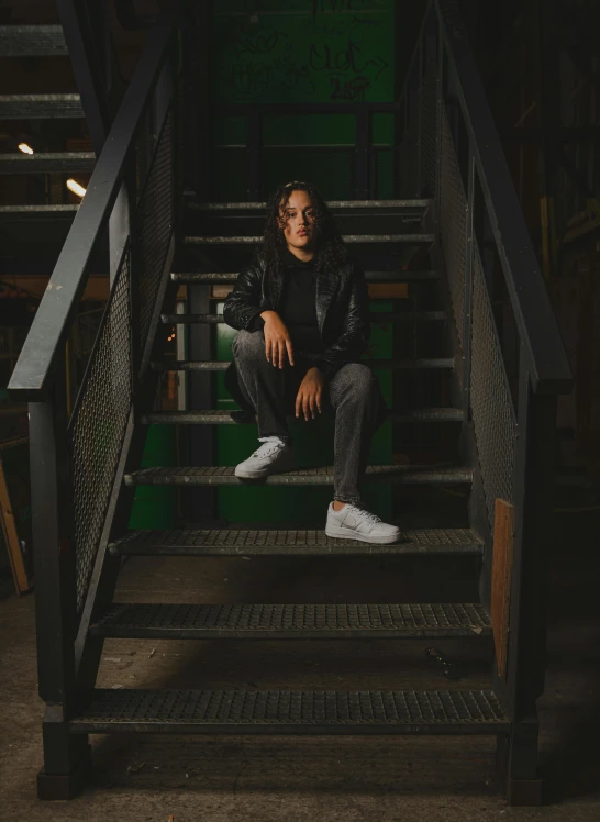 a person sitting on a stair way in front of stairs