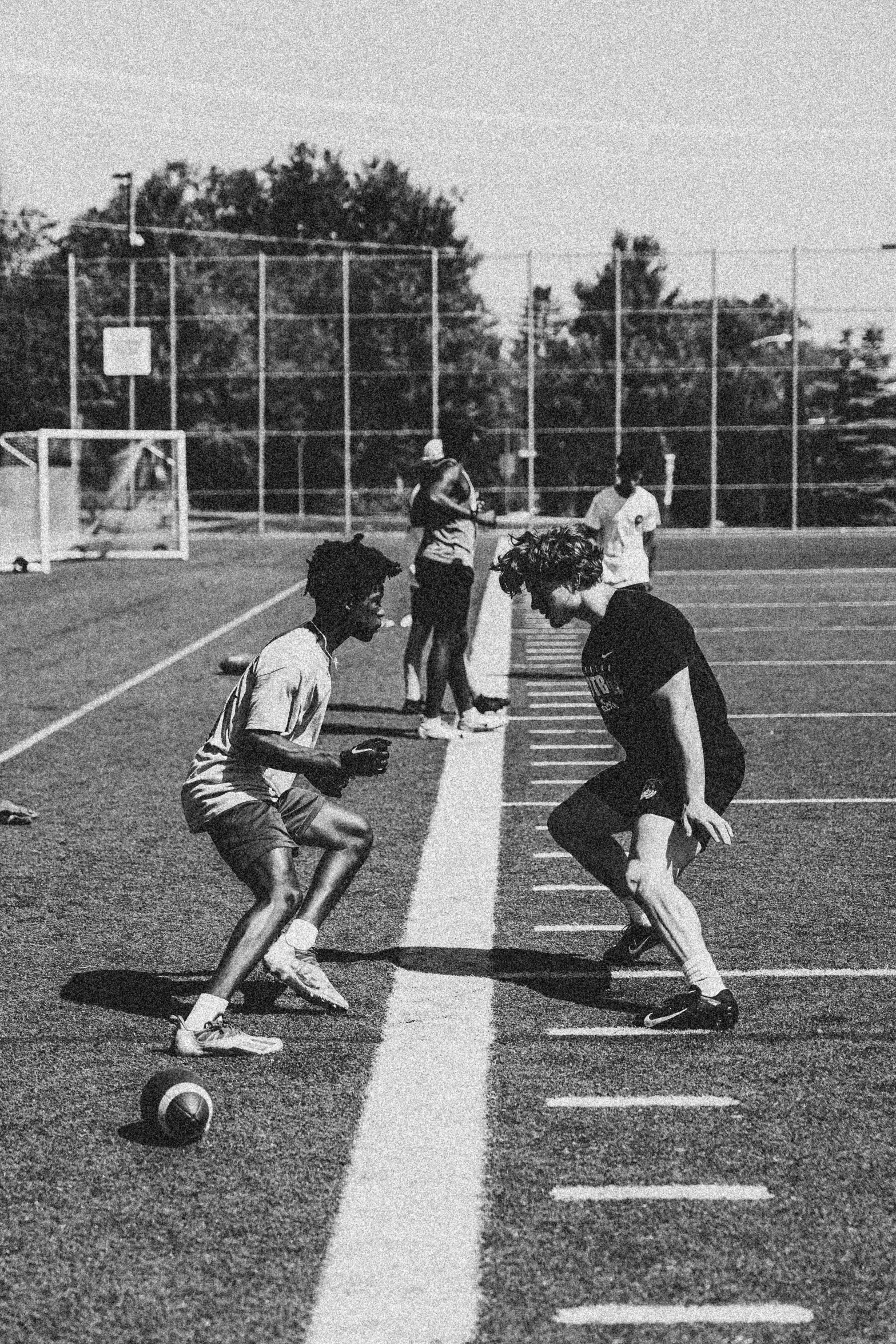 two men are playing soccer on a field