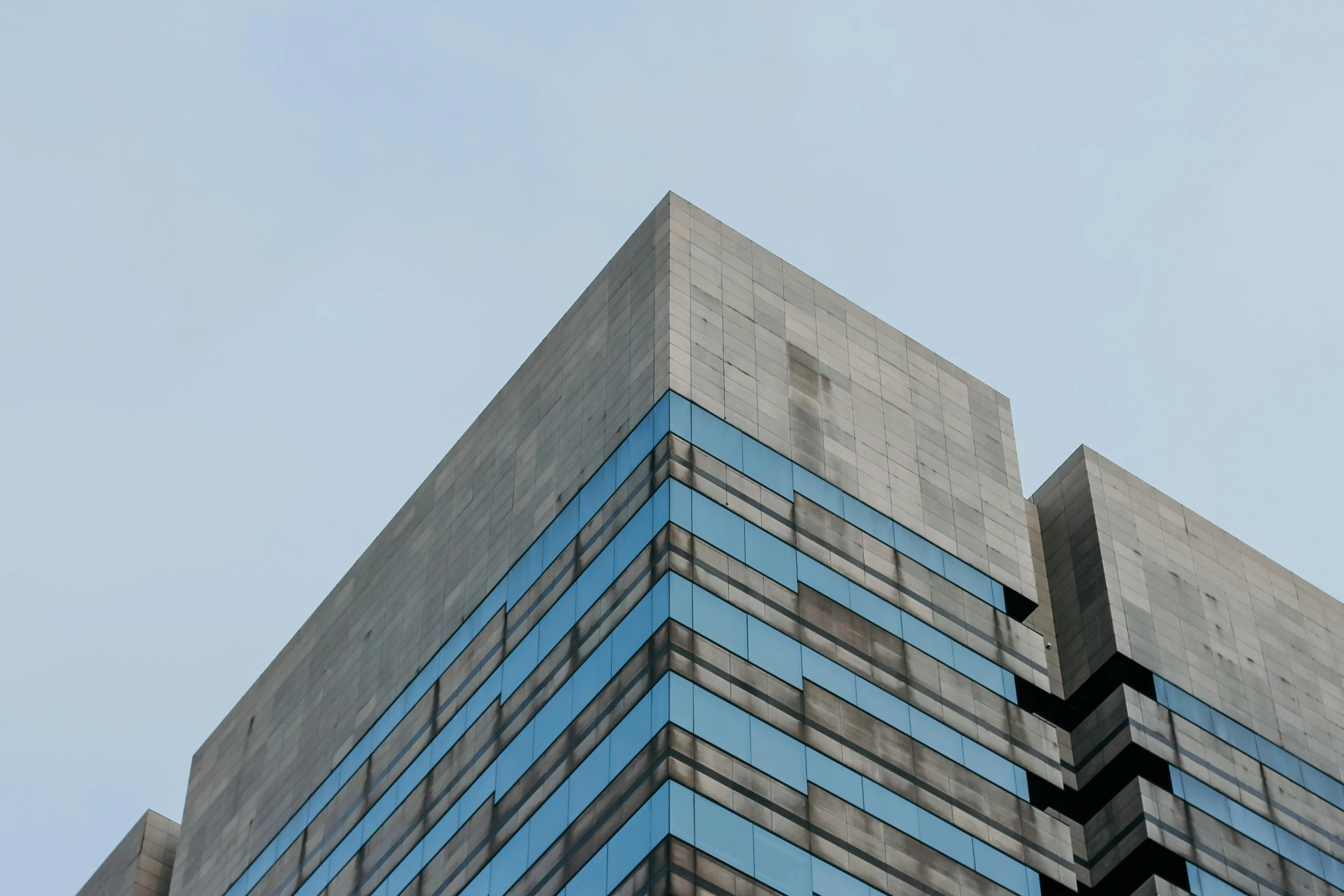 the side of a building made out of multiple strips of glass