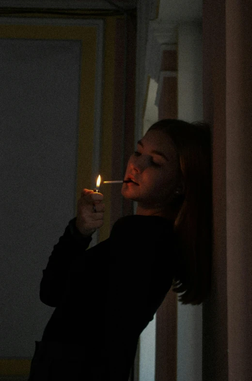 a woman smokes a cigarette while standing in front of a mirror