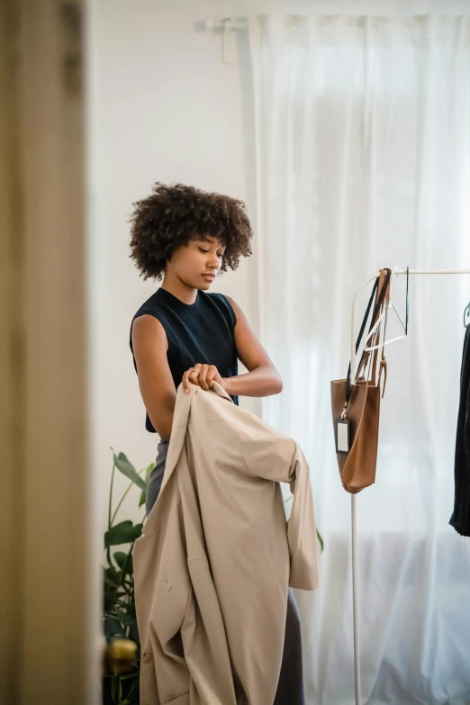 a young woman hanging her clothes on a hanger