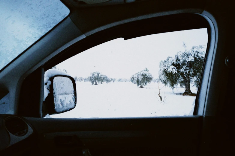 the windshield view of someone in a vehicle on the snow covered road