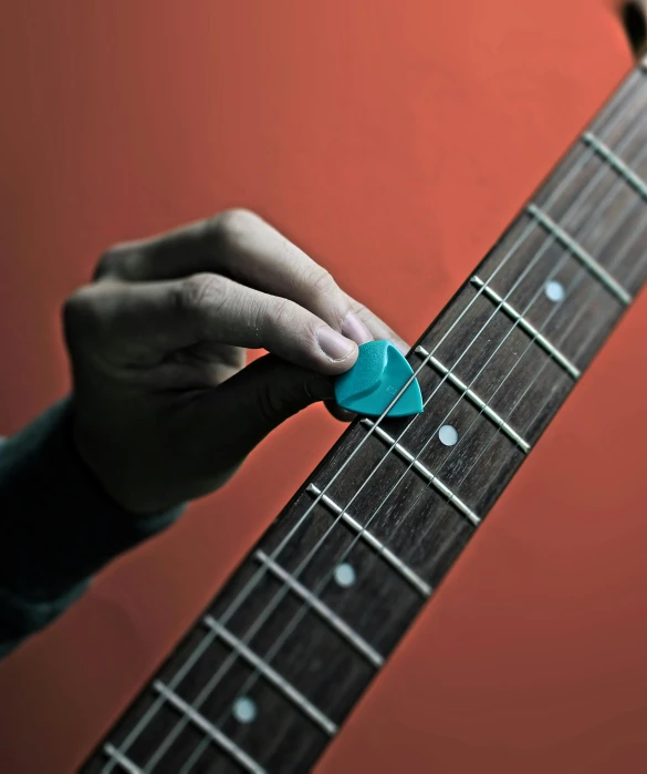 a hand that is holding an acoustic guitar