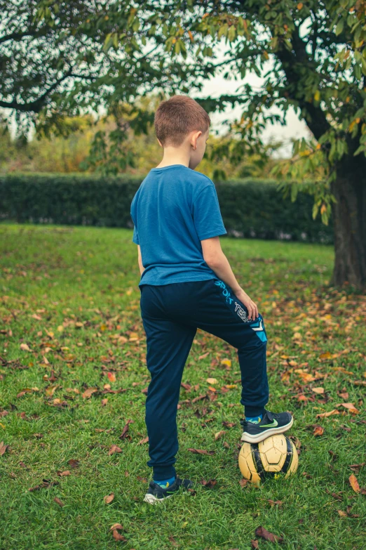 a young man is standing by the soccer ball