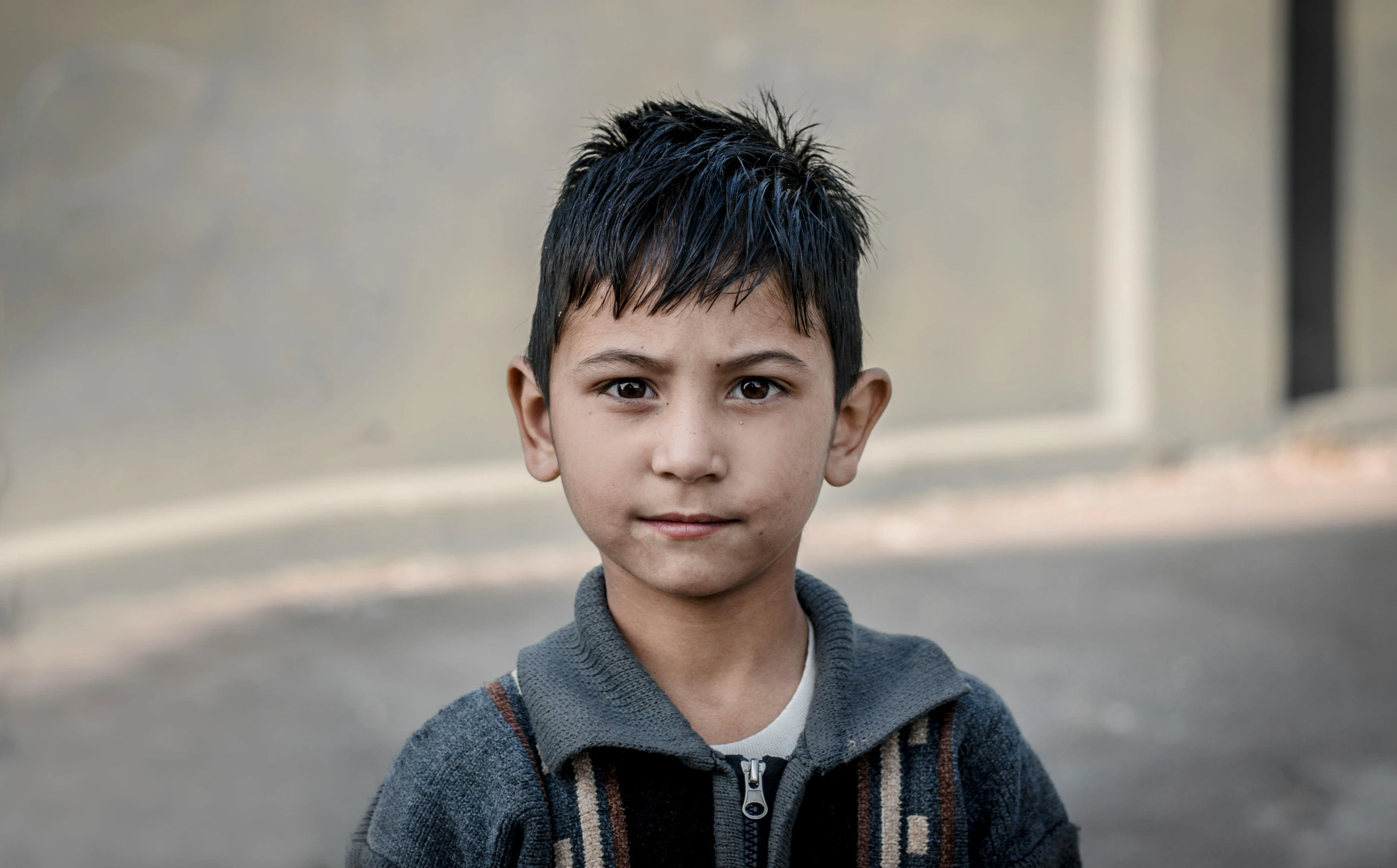 a little boy with short hair looking into the camera