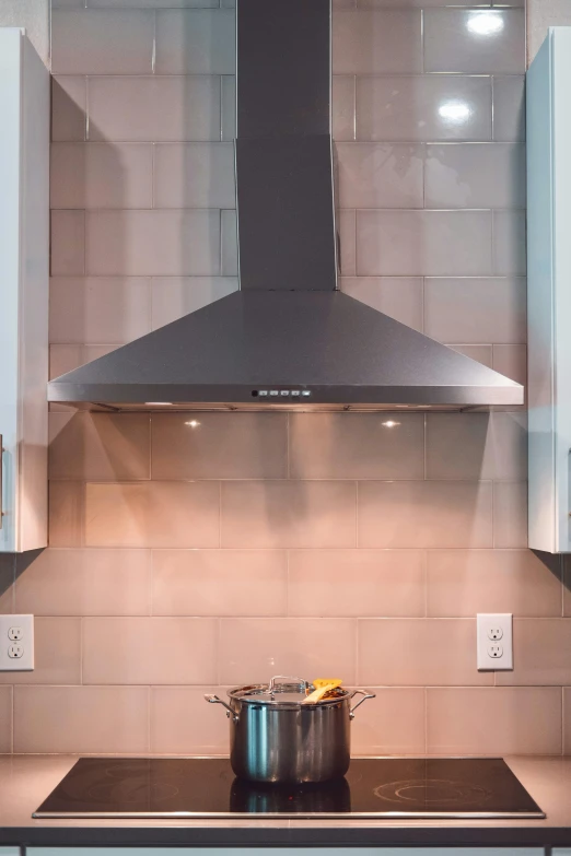 an oven hood and pan are positioned beside a metal cook range