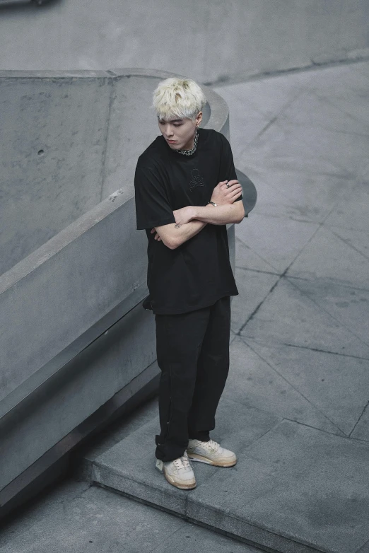 a man standing on concrete stairs with his arms crossed