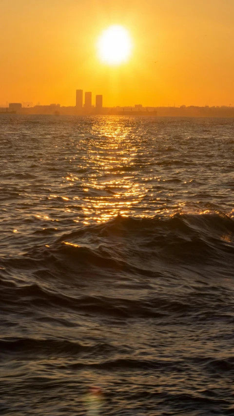 the sun is shining over some buildings in the water