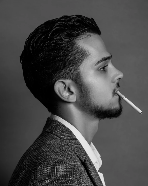 a man in a jacket has his nose covered by a cigarette