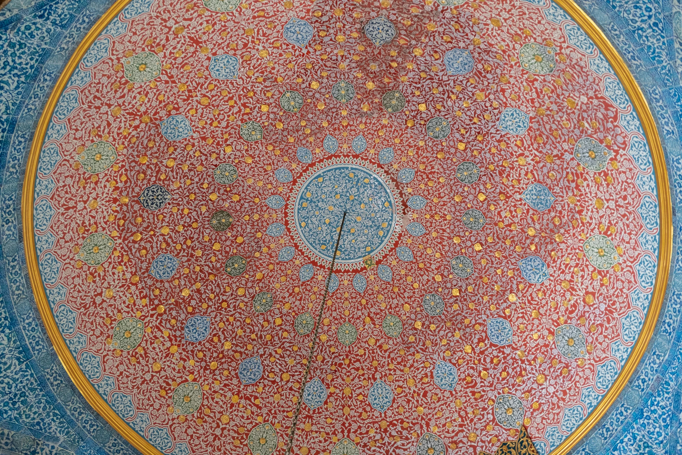 a blue and red patterned ceiling with flowers and circles