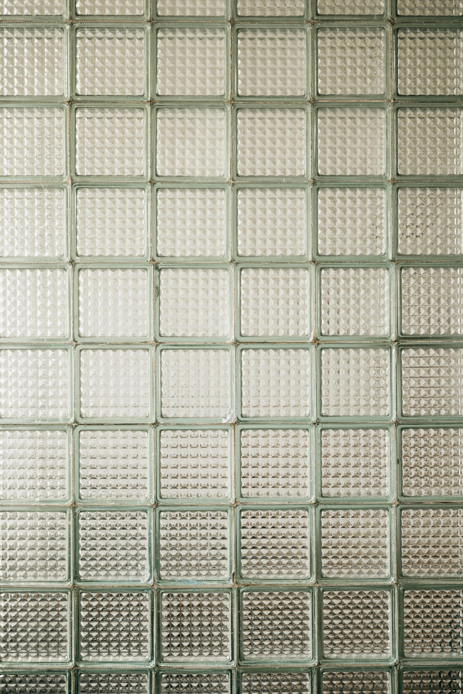 a wall in front of a metal grate with square and rectangular grids on it