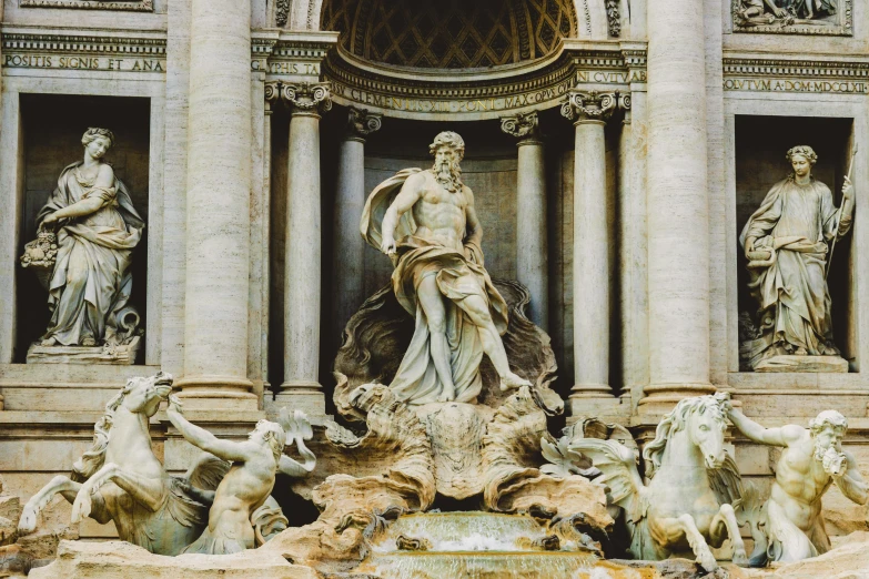 a fountain with statues and water in the background