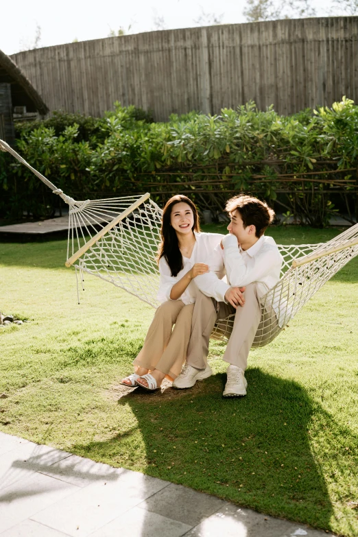 a man and woman sitting in a hammock