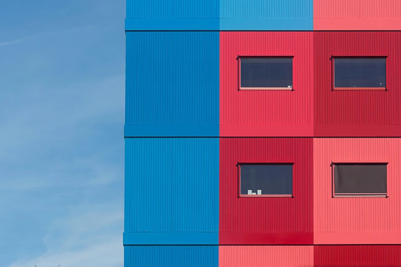 the blue and pink building has small windows