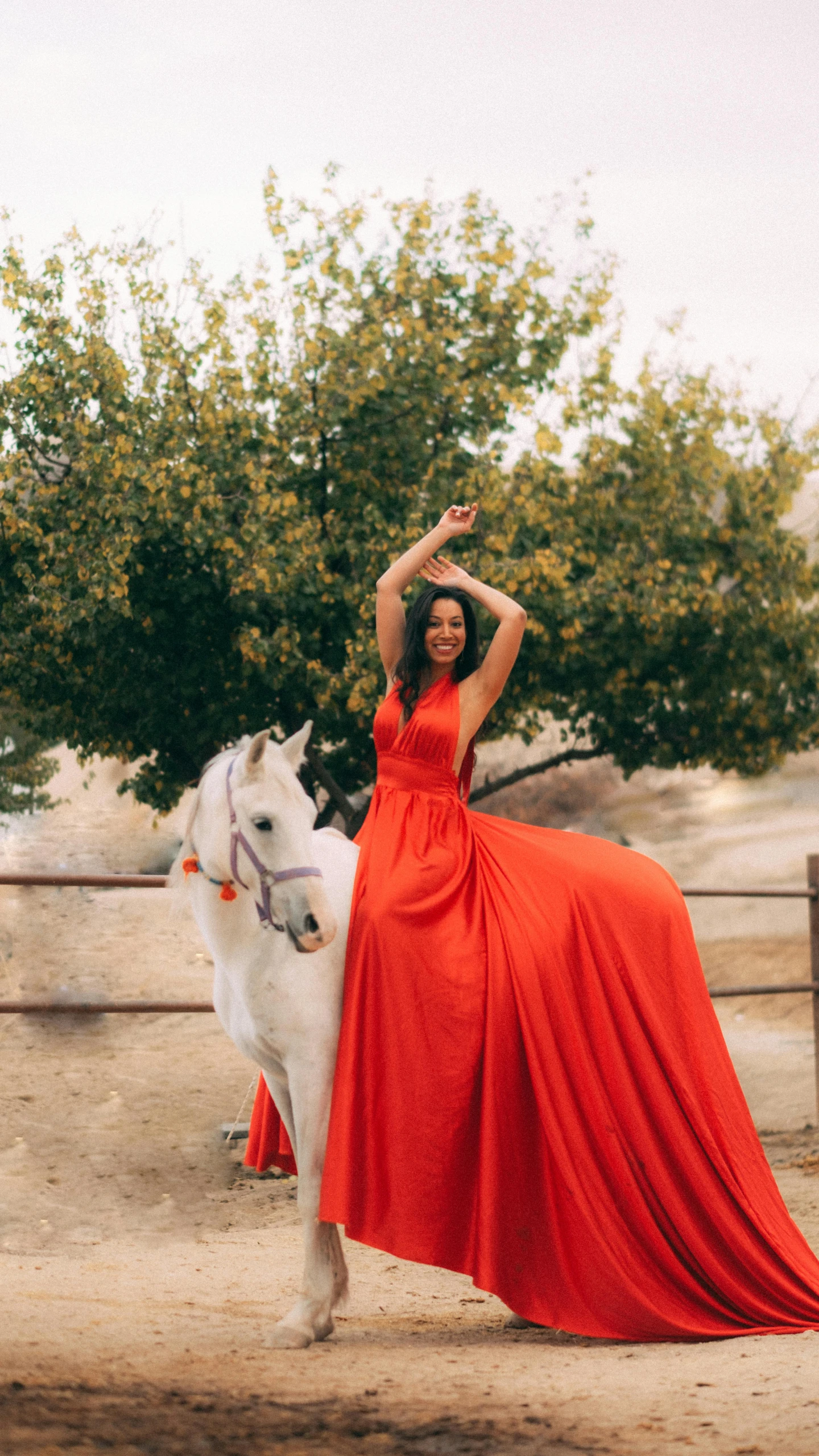 a beautiful woman in a red dress is riding on a white horse