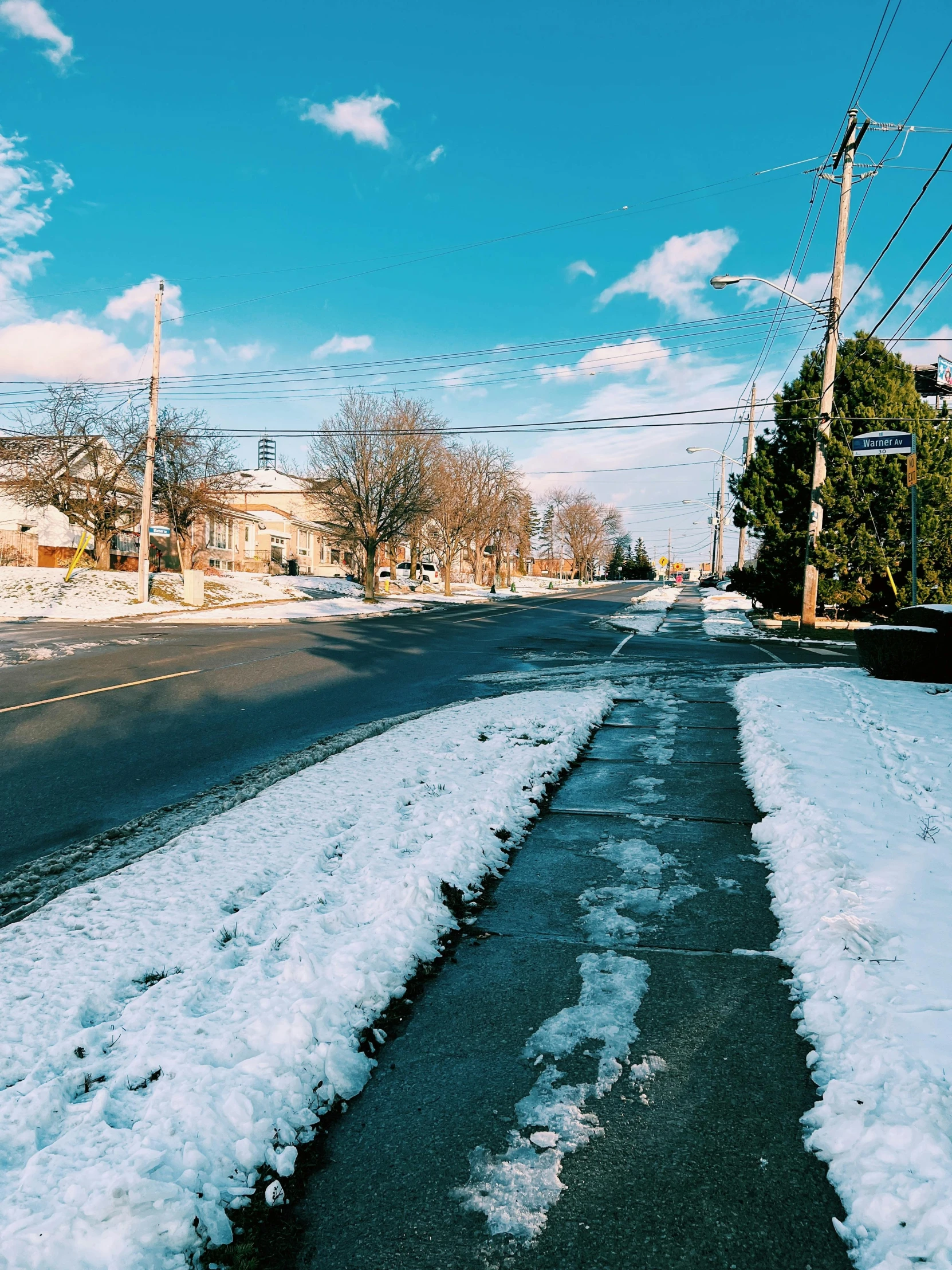 a winter scene with snow on the side of a street