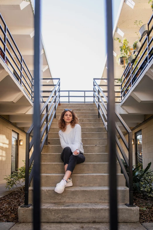 a young woman is sitting on the steps to a building