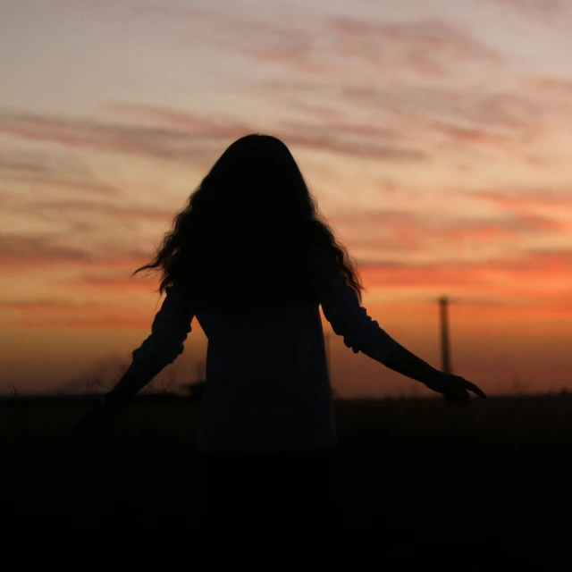 there is a woman with long hair standing in the grass