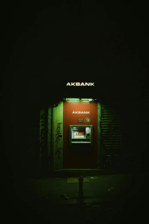 an atm machine sits outside a bank at night