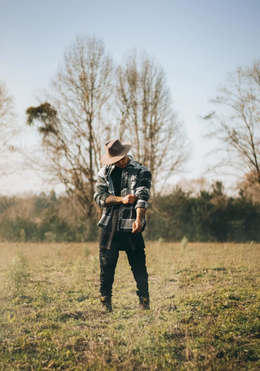 a man standing in a field holding a camera