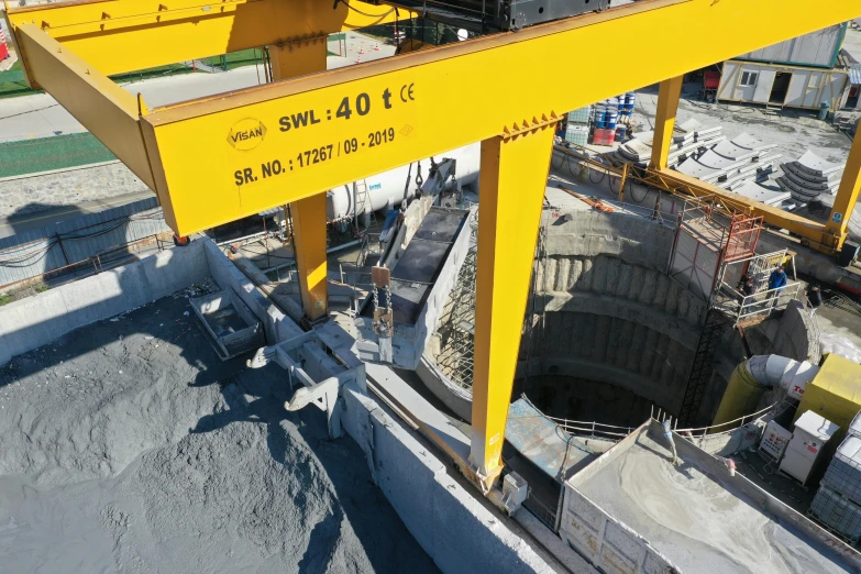 a yellow crane that is standing on some concrete