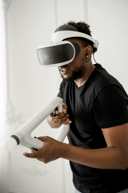 a man with head mounted virtual glasses holding a toy