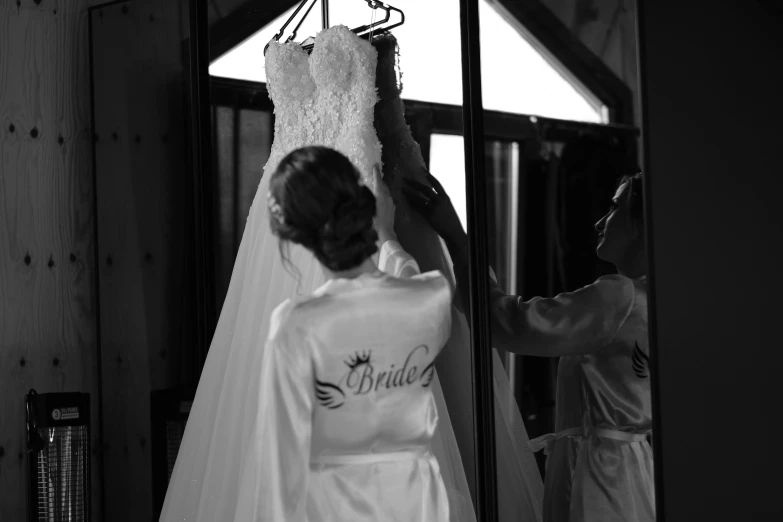 a brides dress hanging off of a door at her wedding