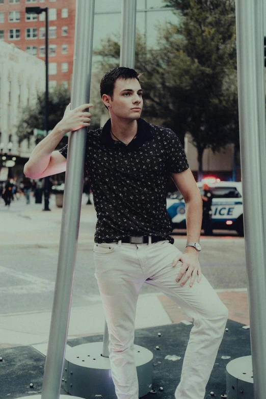 a man standing on the street holding onto the pole