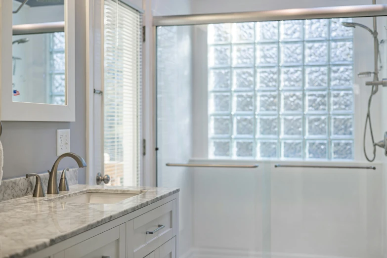 a glass block shower is in this white bathroom