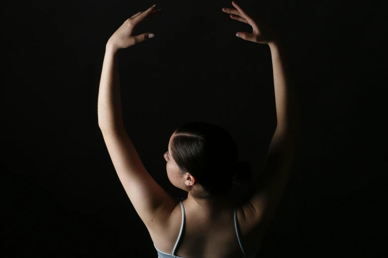 a woman wearing white top holding her arms up