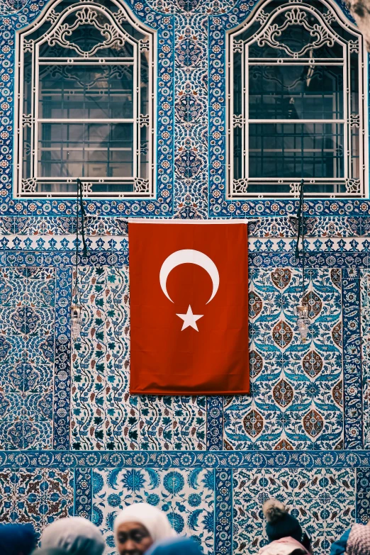 a red flag on the side of a building with a pattern on it