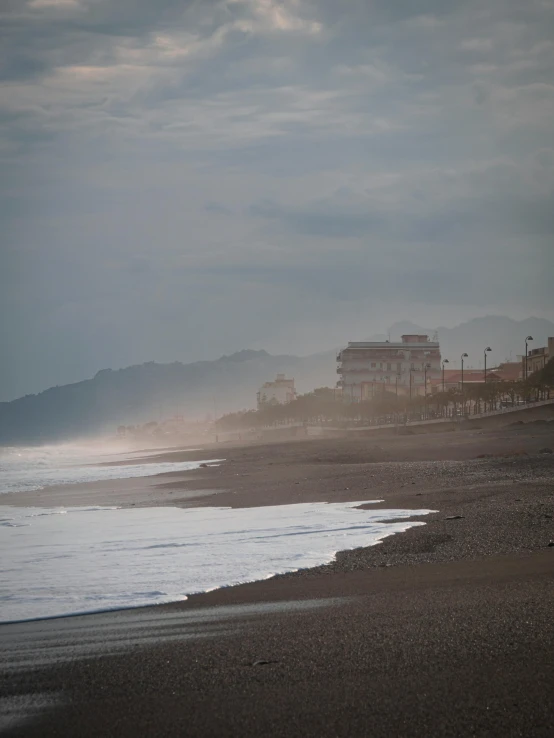 ocean front line with buildings under cloudy sky