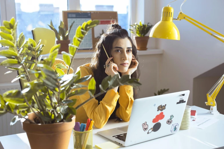 a woman talking on her cell phone at her desk